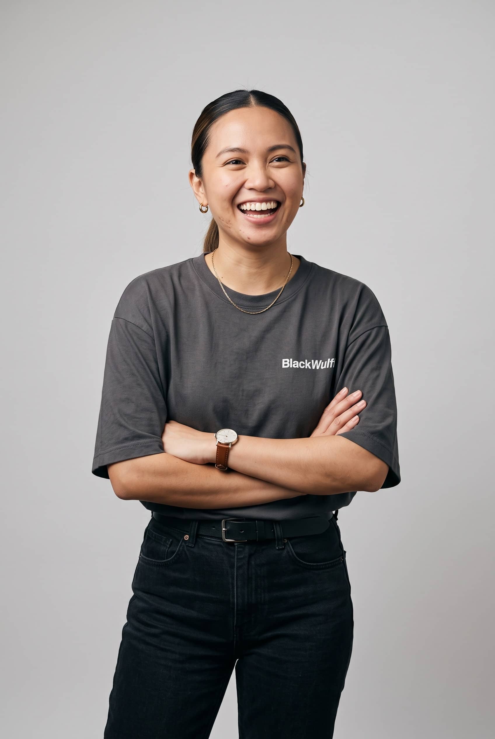 Executive assistant standing, arms crossed, smiling