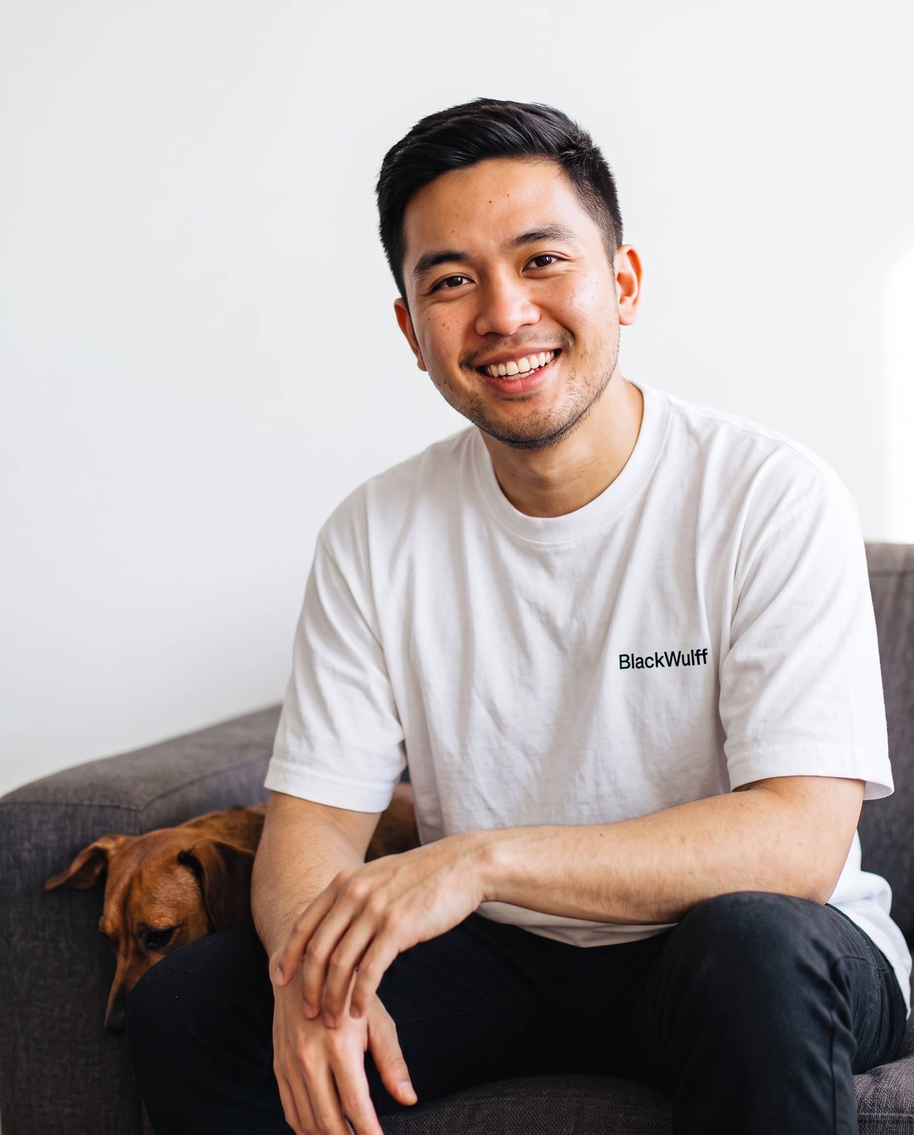 Team member smiling, seated at home